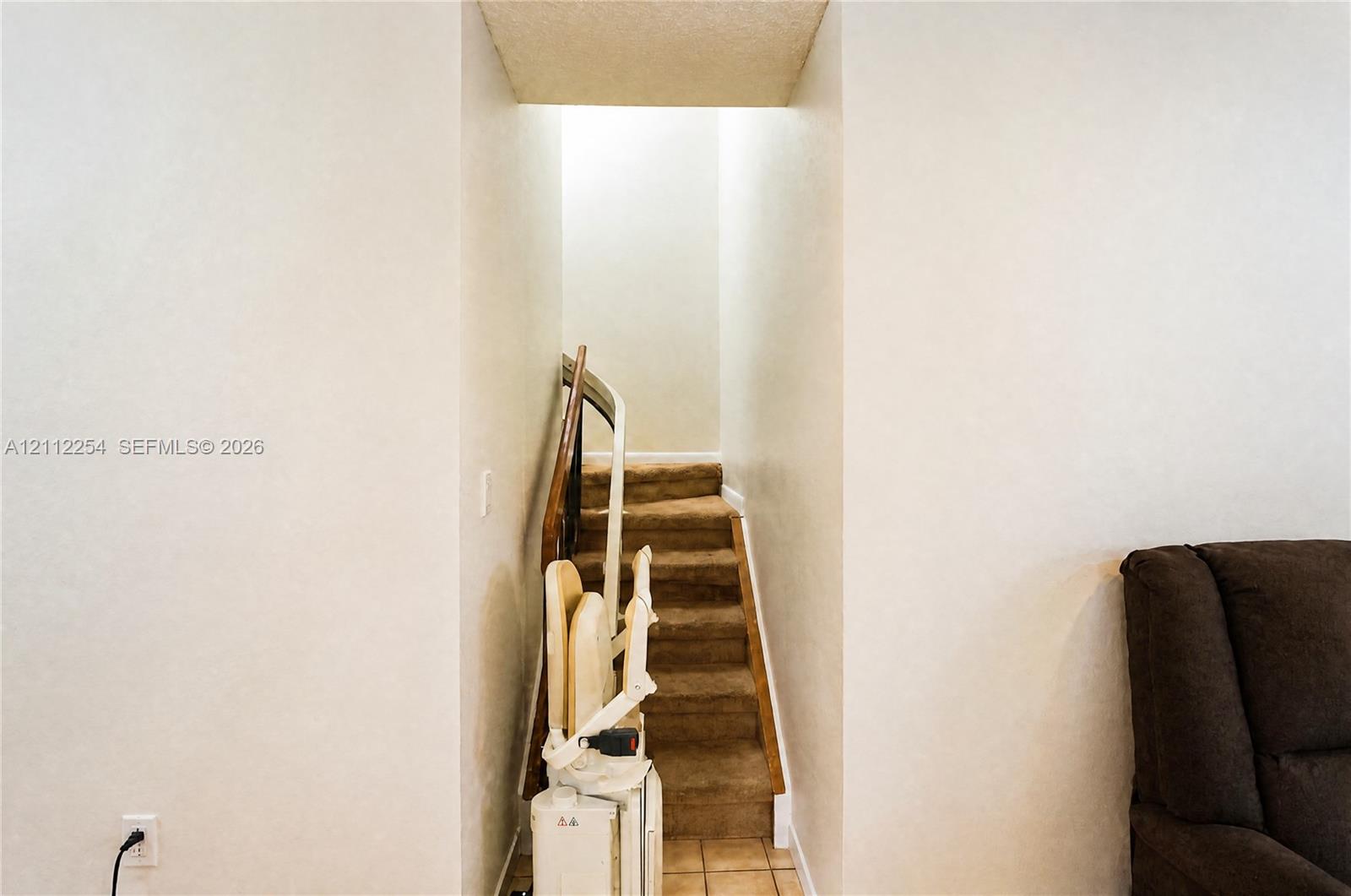 Staircase featuring wall-to-wall carpeting and a motorized stair lift
