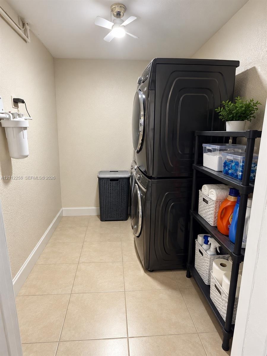 Dedicated laundry area featuring ceramic tile flooring, neutral wall tones, and a ceiling-mounted light fixture Dedicated laundry area featuring ceramic tile flooring, neutral wall tones, and a ceiling-mounted light fixture