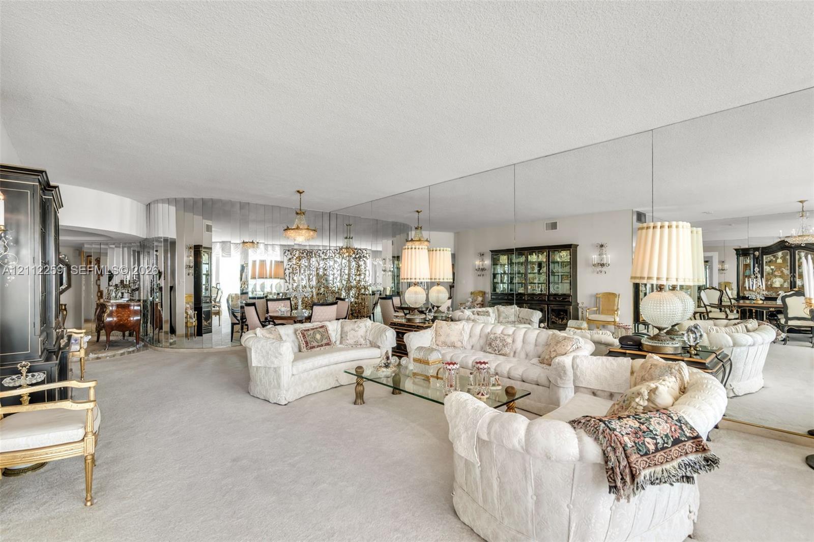 Expansive room featuring floor-to-ceiling wall mirrors and custom curved architectural detailing