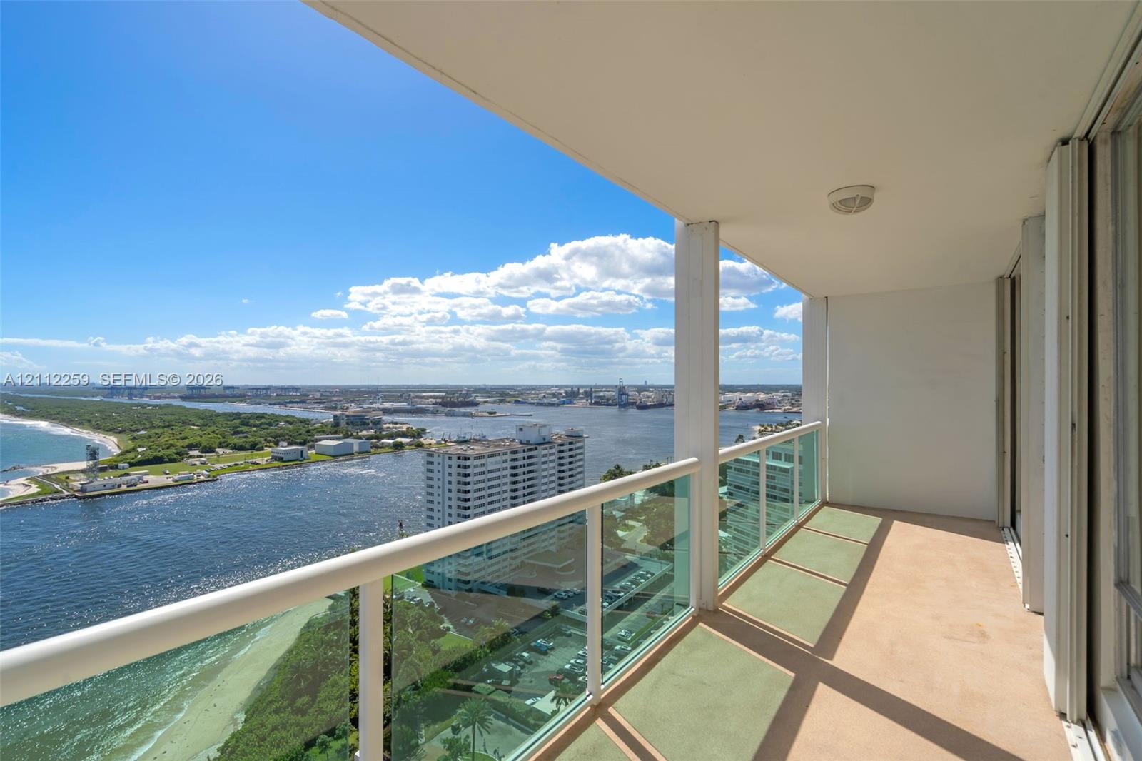 Private balcony featuring a glass panel railing and panoramic waterfront and coastal scenery Private balcony featuring a glass panel railing and panoramic waterfront and coastal scenery