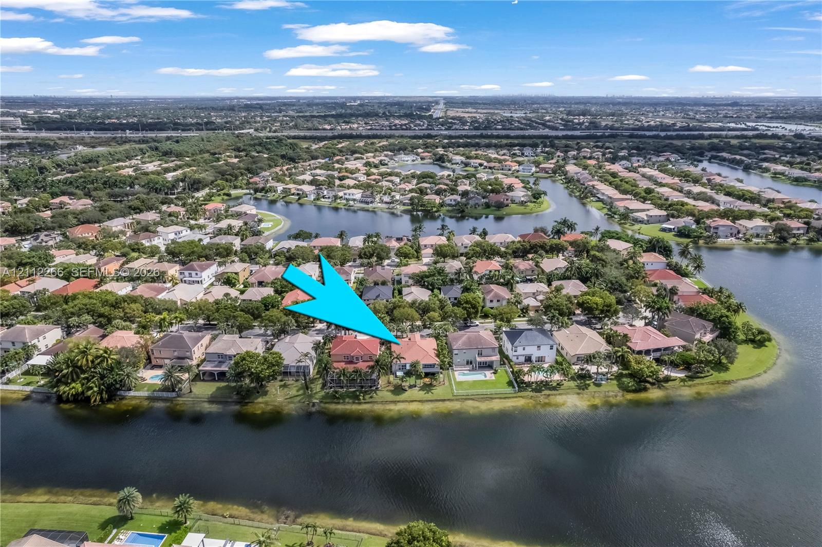Aerial perspective featuring a waterfront property with a tile roof and a private rear swimming pool
