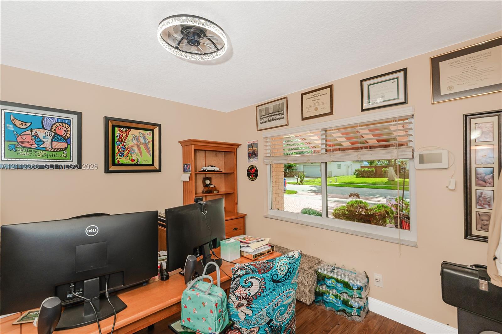 Room featuring a circular LED-integrated ceiling fixture, wood-finish flooring, and a large horizontal window with neutral blinds