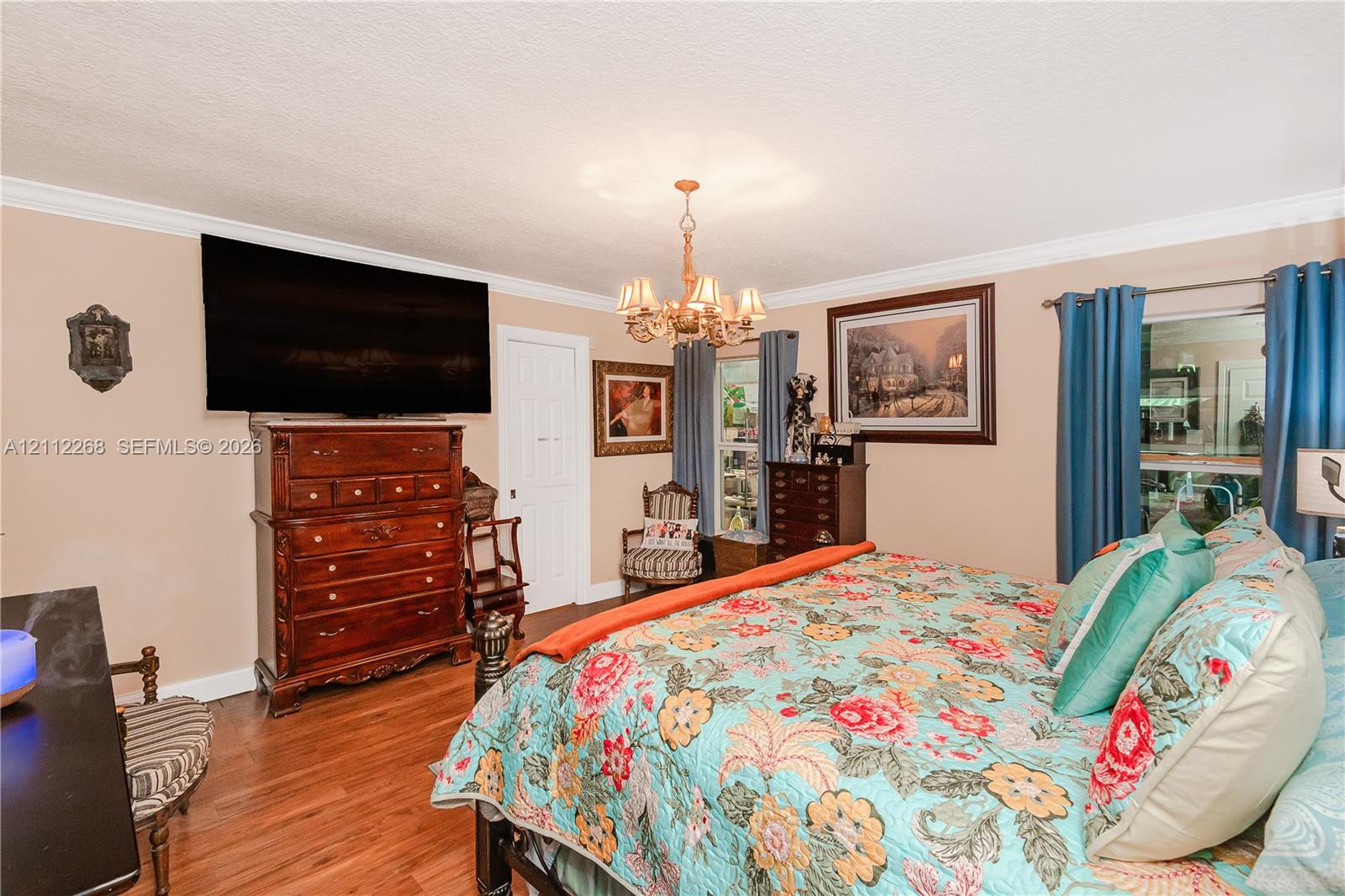 Wood-finish flooring, multi-arm metal chandelier, and crown molding