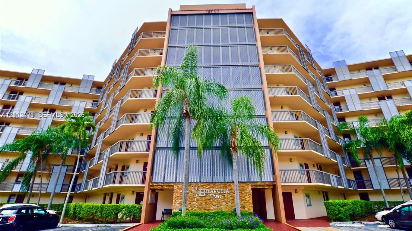 Multi-story architectural exterior featuring tiered private balconies with metal railings, full-height window panels, and natural stone veneer accents Multi-story architectural exterior featuring tiered private balconies with metal railings, full-height window panels, and natural stone veneer accents