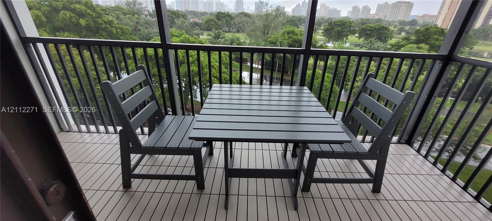 Screened balcony featuring dark metal railings and tiled flooring
