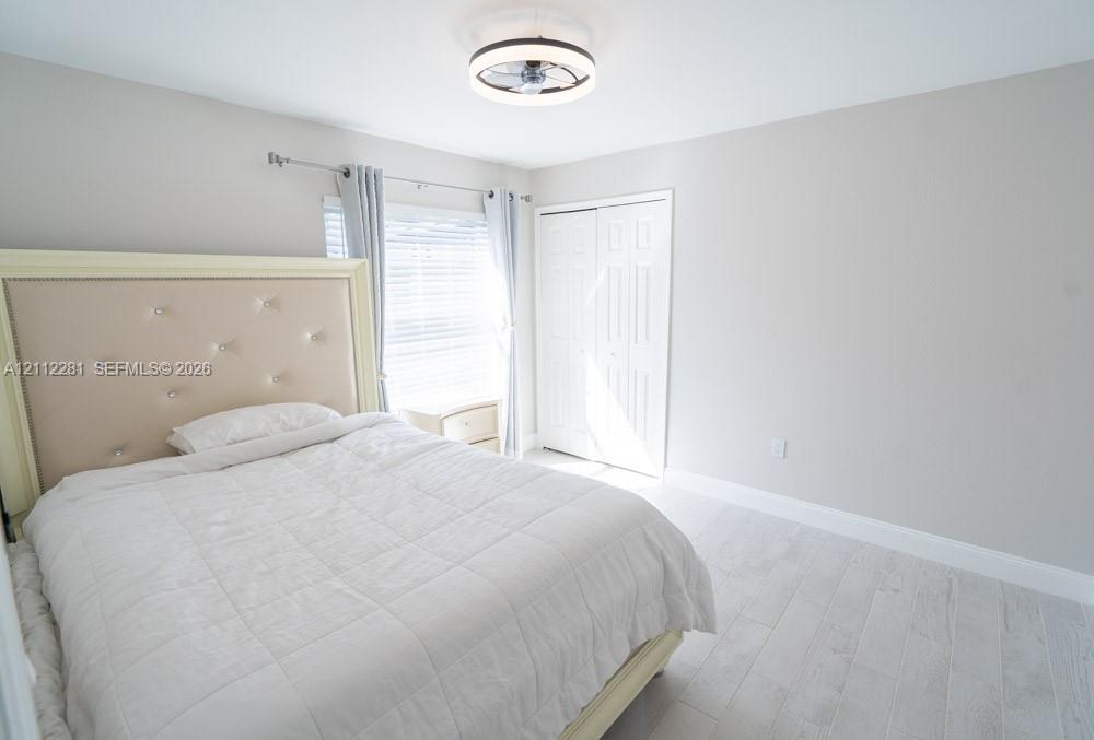 Neutral wall tones, wood-finish flooring, double-panel closet doors, and a low-profile integrated ceiling light fixture