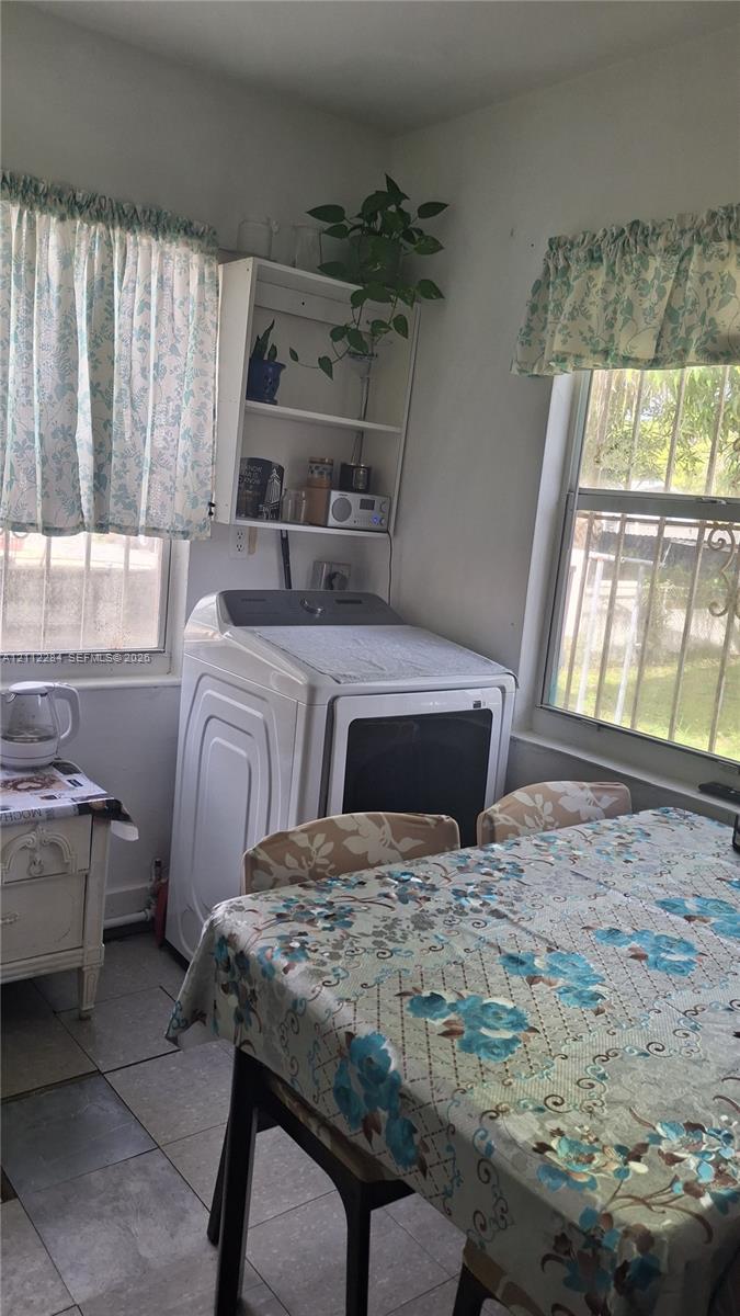 Laundry area featuring tile flooring, dual windows, and built-in open shelving