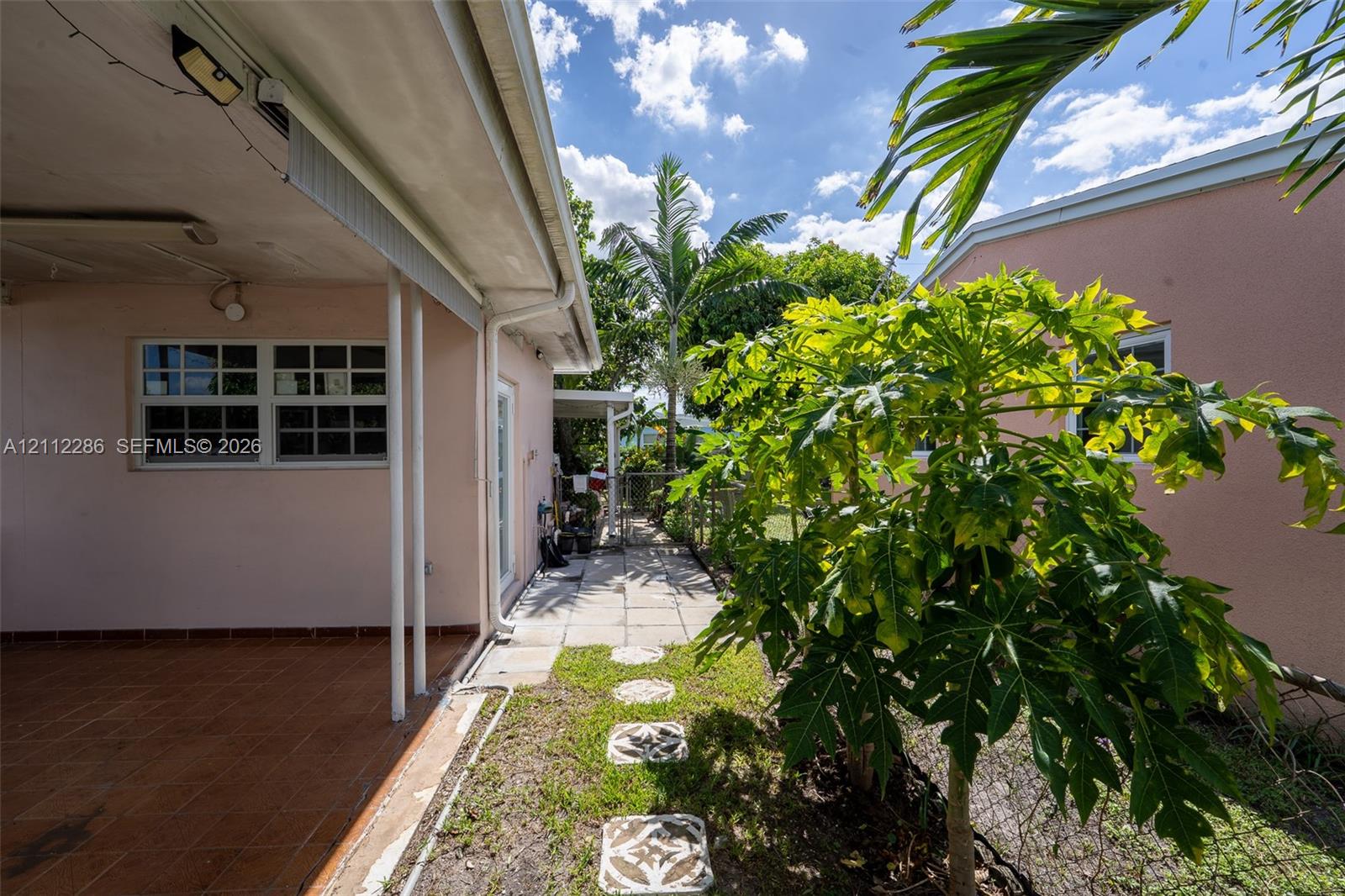 Covered patio with tiled flooring, concrete paver walkway, and exterior stucco finish Covered patio with tiled flooring, concrete paver walkway, and exterior stucco finish