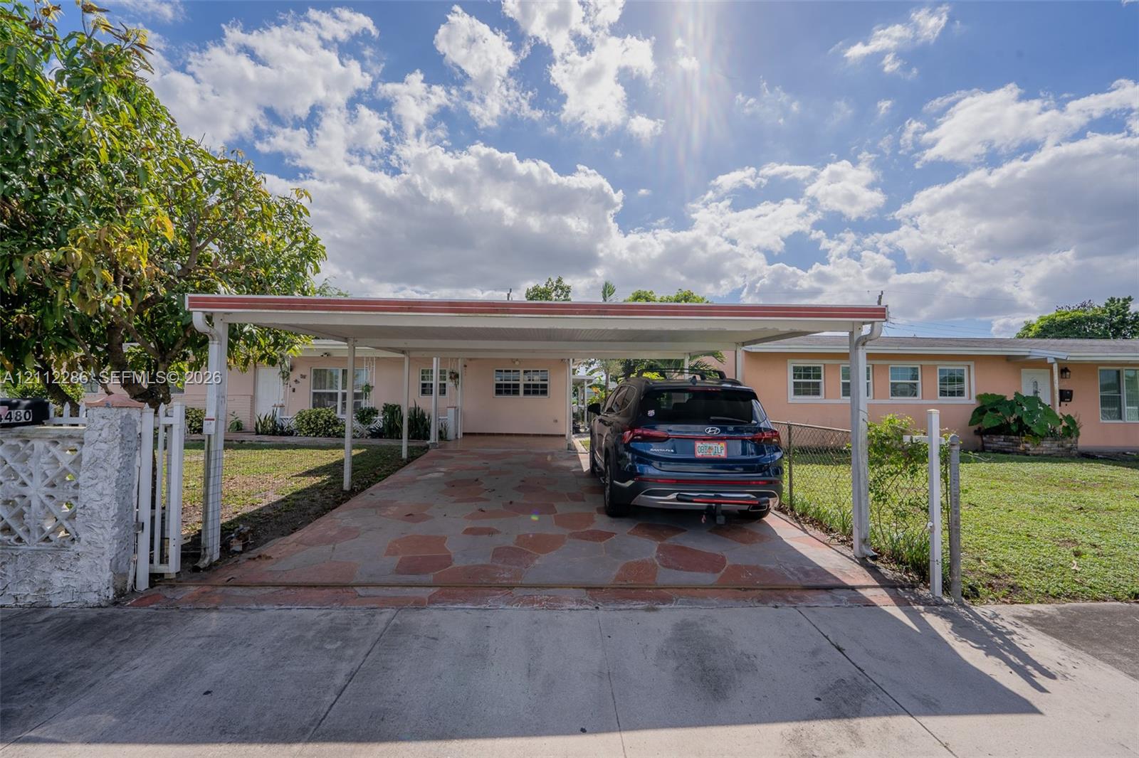 Covered carport featuring a decorative stone-paved floor and a concrete masonry unit fence Covered carport featuring a decorative stone-paved floor and a concrete masonry unit fence