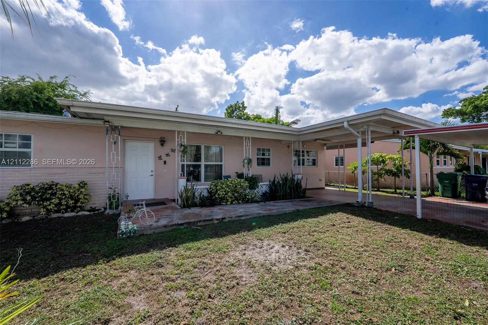 Single-story residence featuring a masonry exterior, stone-paved entry porch, attached carport, and metal roofing Single-story residence featuring a masonry exterior, stone-paved entry porch, attached carport, and metal roofing