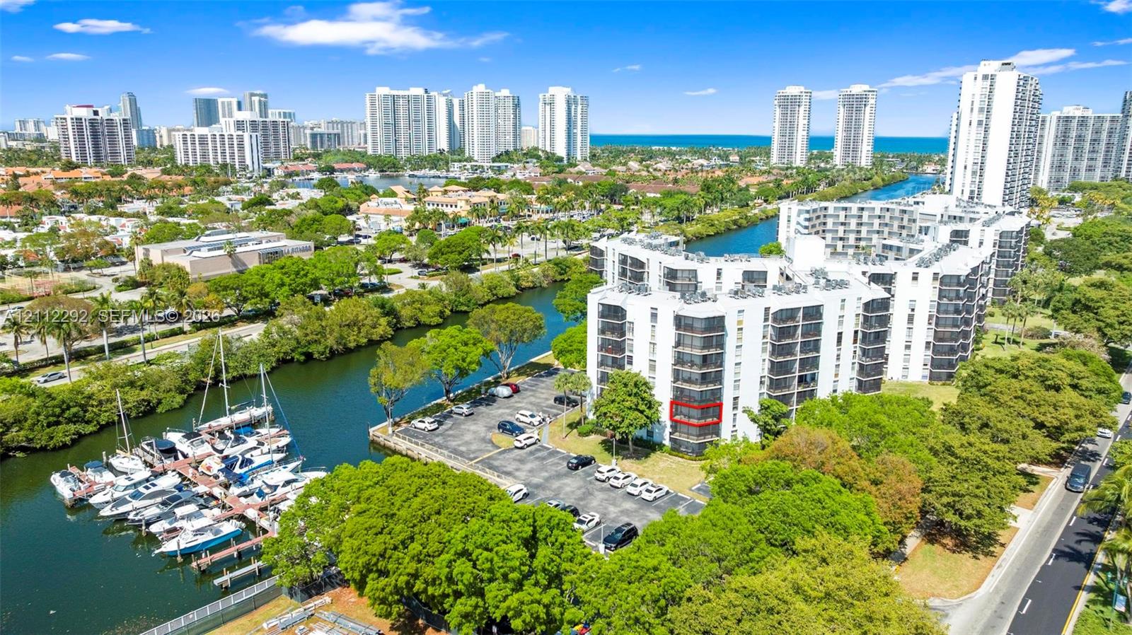 Multi-story residential building featuring private balconies, surface parking, and waterfront bulkhead infrastructure with direct water access Multi-story residential building featuring private balconies, surface parking, and waterfront bulkhead infrastructure with direct water access