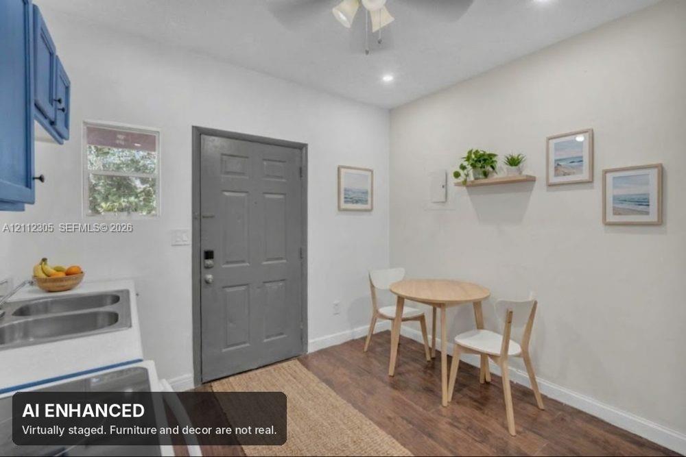 Covered entryway featuring a textured stucco exterior, a solid six-panel door, an exterior wall-mounted light fixture, and a masonry planter box