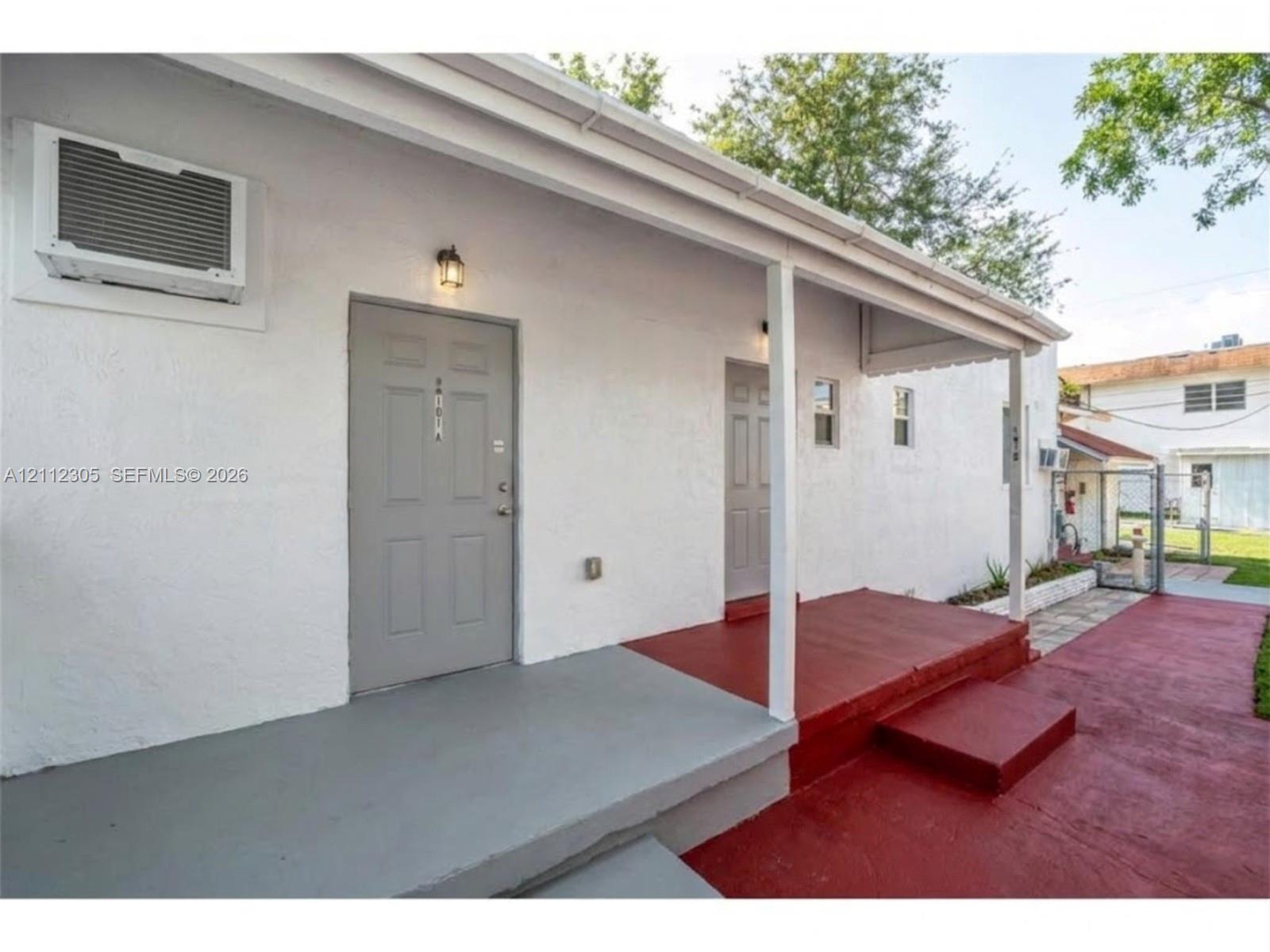 AI enhanced: porch cleaned and repainted, wall AC unit replaced, clutter removed. Possible improvement, not the current condition. The unaltered original is the previous photo.