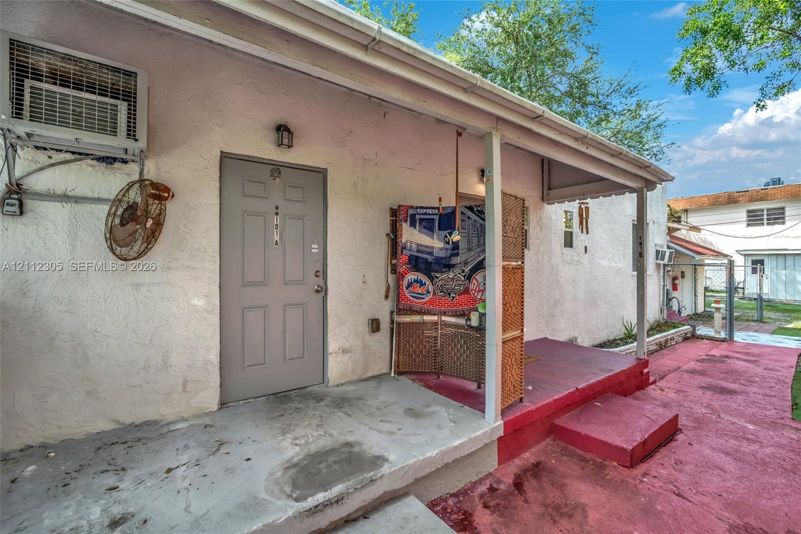 Stucco exterior featuring a covered porch, recessed exterior lighting, and painted concrete hardscaping