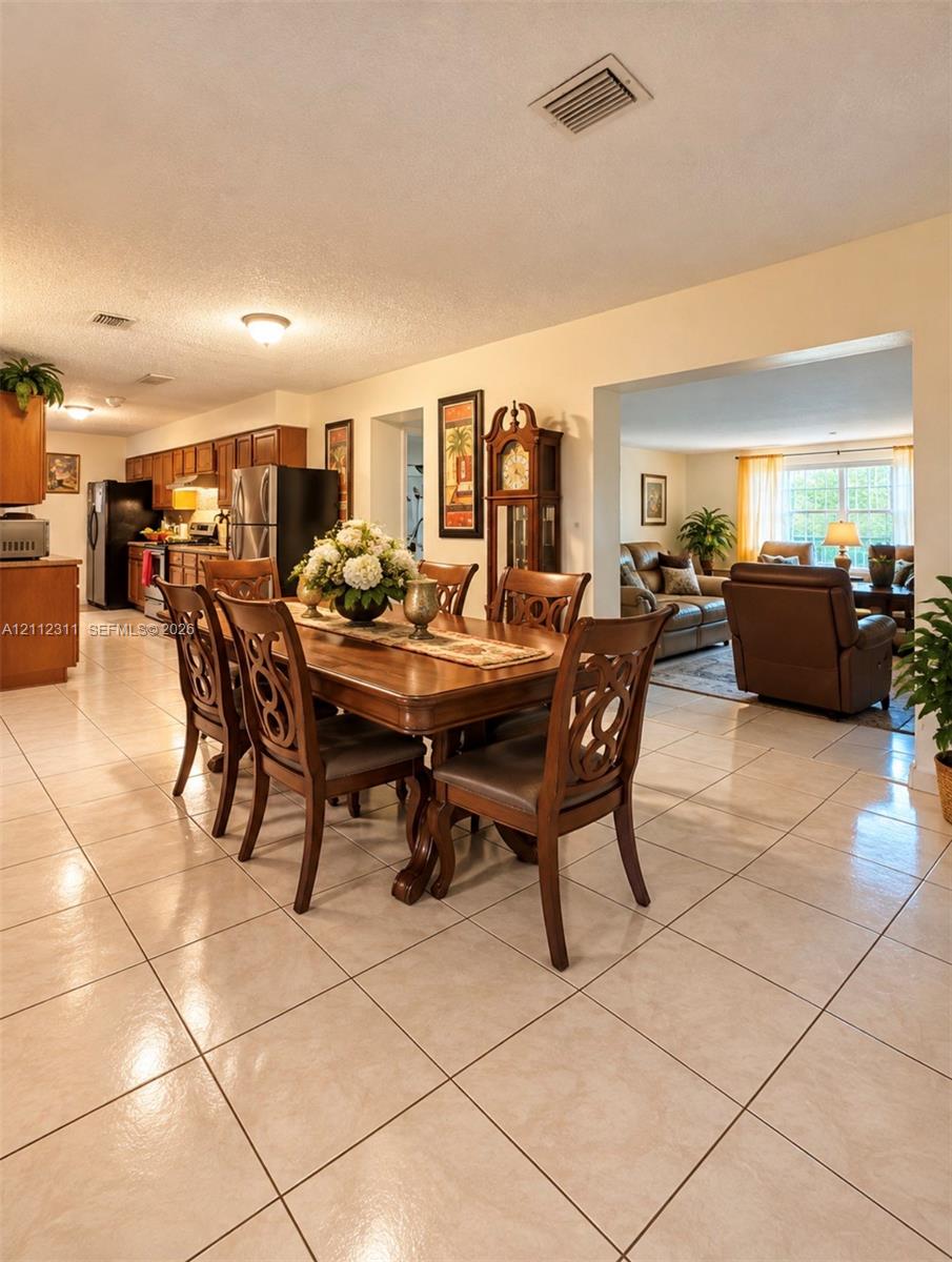 Tile flooring throughout the main living areas, kitchen cabinetry with neutral countertops, and recessed ceiling lighting