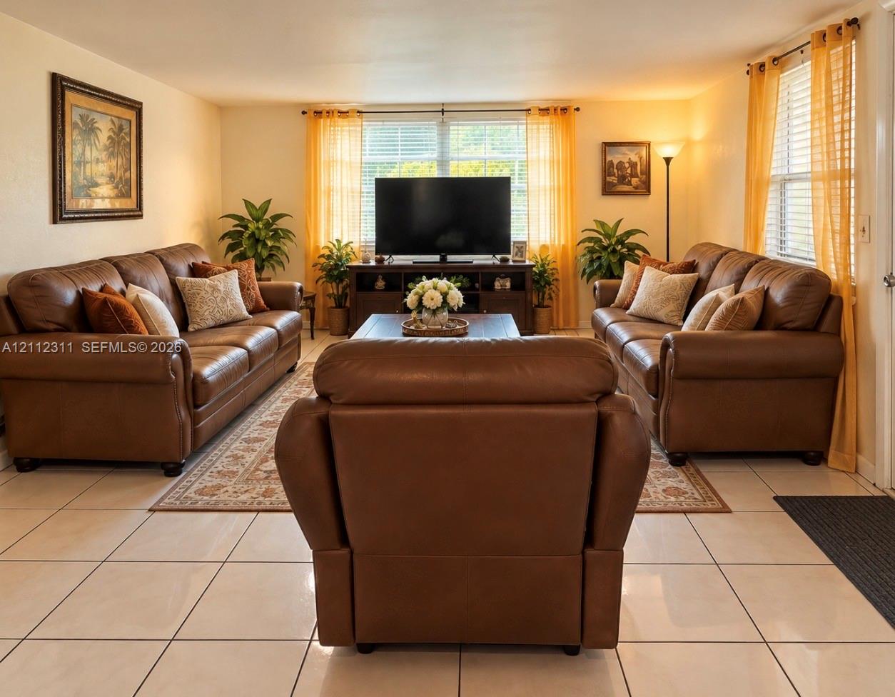 Large-format neutral tile flooring and natural light through multiple windows