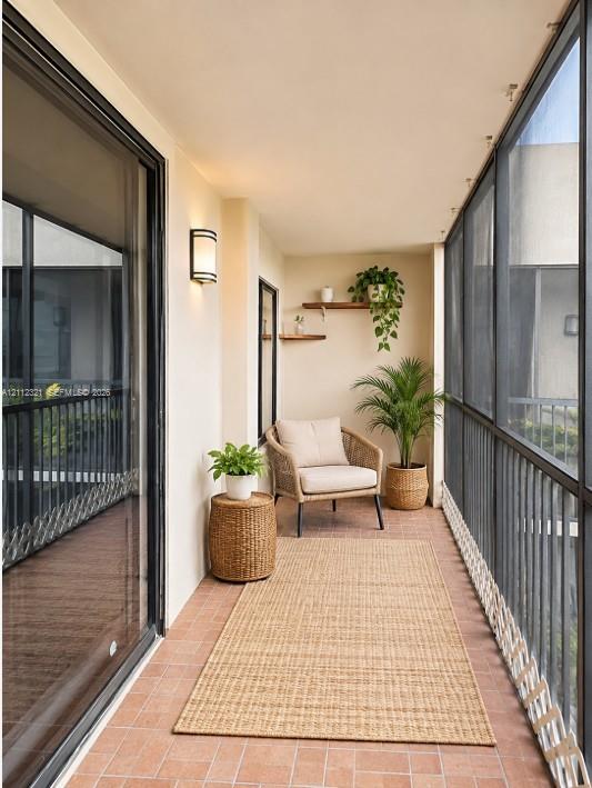 Covered balcony featuring terracotta-tile flooring, metal screen enclosure, wall-mounted exterior light fixture, and two built-in floating shelves Covered balcony featuring terracotta-tile flooring, metal screen enclosure, wall-mounted exterior light fixture, and two built-in floating shelves
