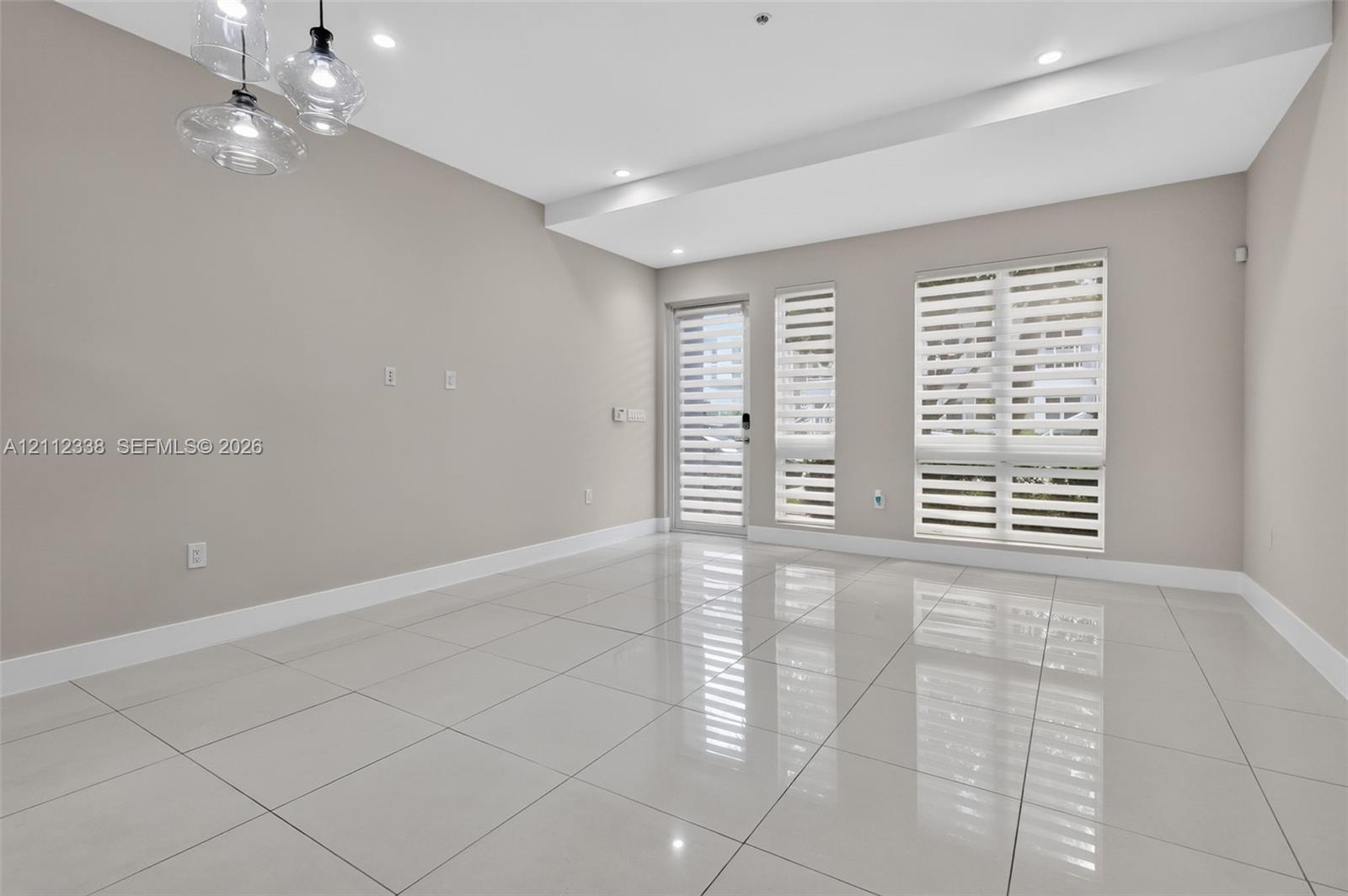 Large-format polished tile flooring, recessed ceiling lighting, multi-pendant glass light fixture, and windows featuring dual-layer horizontal blinds Large-format polished tile flooring, recessed ceiling lighting, multi-pendant glass light fixture, and windows featuring dual-layer horizontal blinds