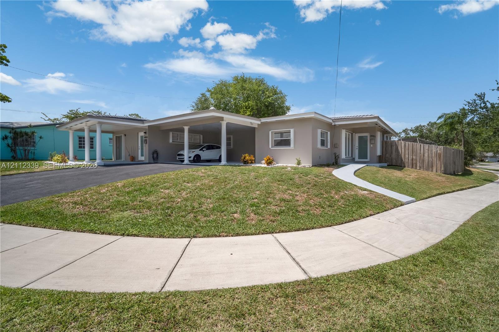 Fully renovated single-story duplex in light-toned exterior finish, and fenced yard area