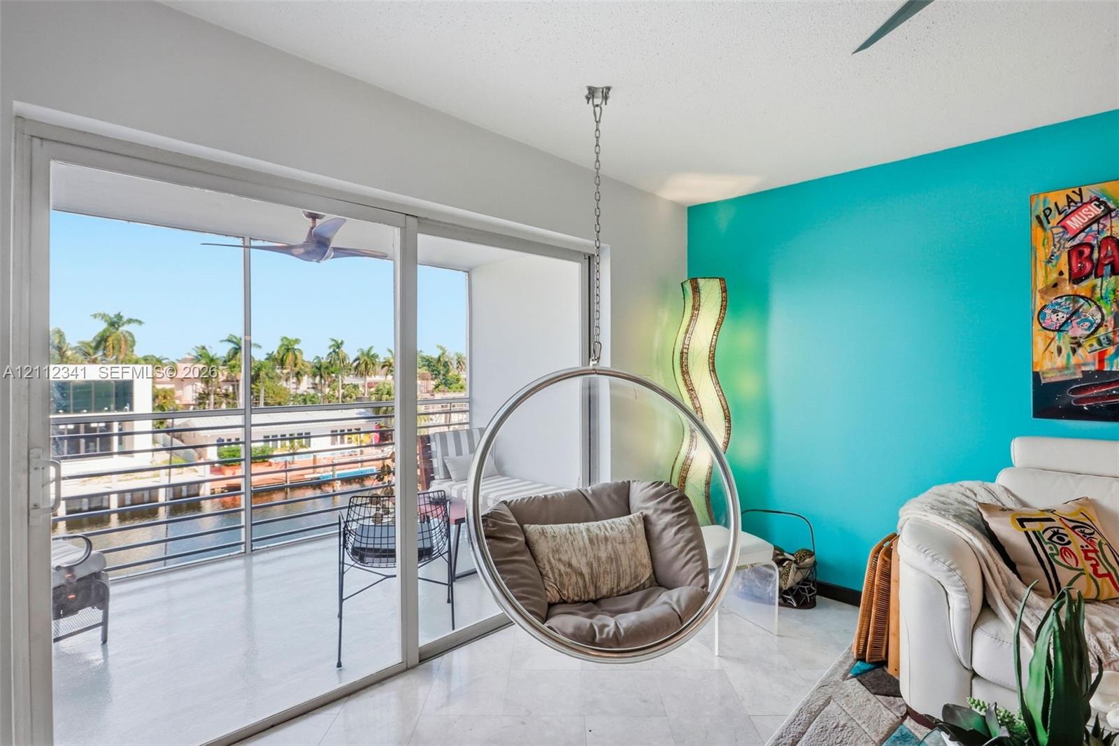 Sliding glass doors providing access to a screened balcony, stone-finish flooring, and a ceiling-mounted light fixture Sliding glass doors providing access to a screened balcony, stone-finish flooring, and a ceiling-mounted light fixture