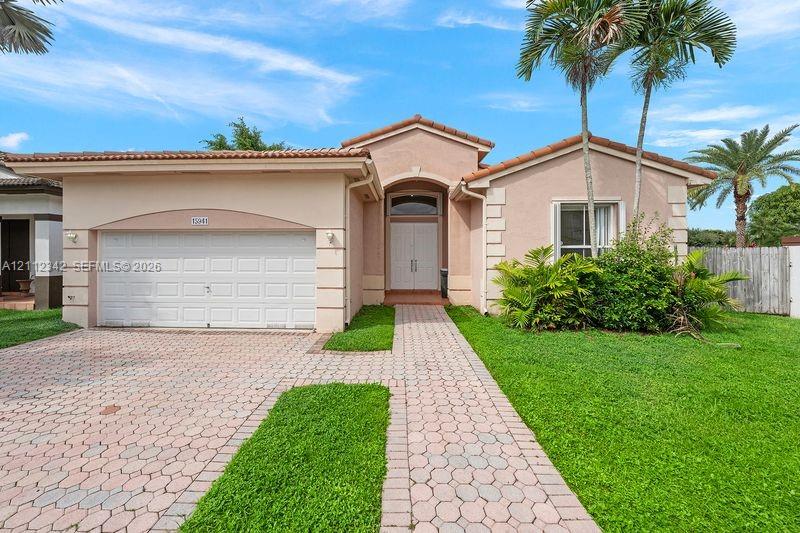Single-story exterior featuring a stucco facade, tile roof, arched entryway with double front doors, paved driveway and walkway, and a multi-section garage door Single-story exterior featuring a stucco facade, tile roof, arched entryway with double front doors, paved driveway and walkway, and a multi-section garage door