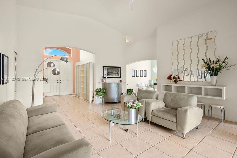 High ceilings, tiled flooring, arched entryways, and a wall-mounted built-in console