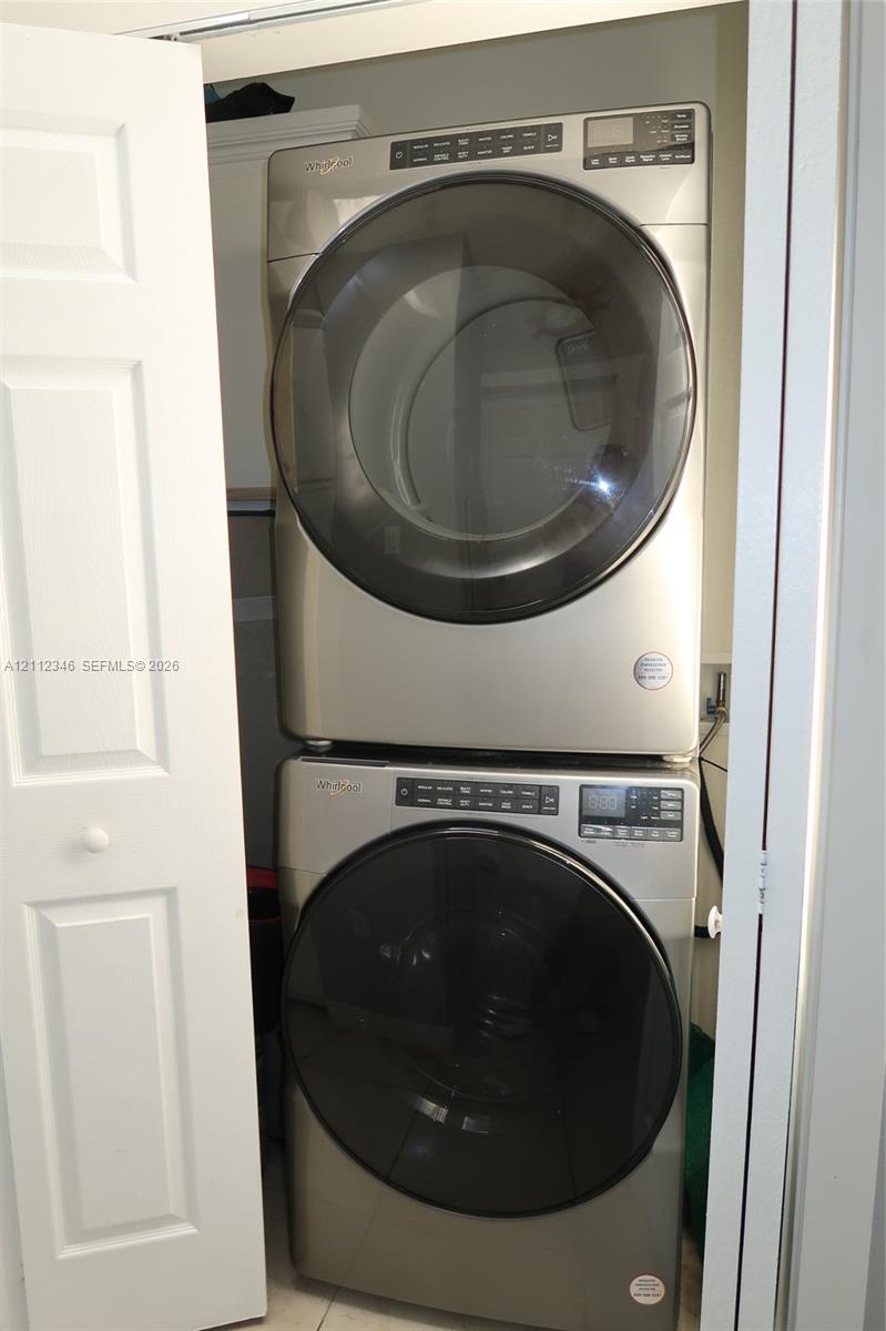 Stacked front-load metallic-finish laundry set housed within a dedicated closet