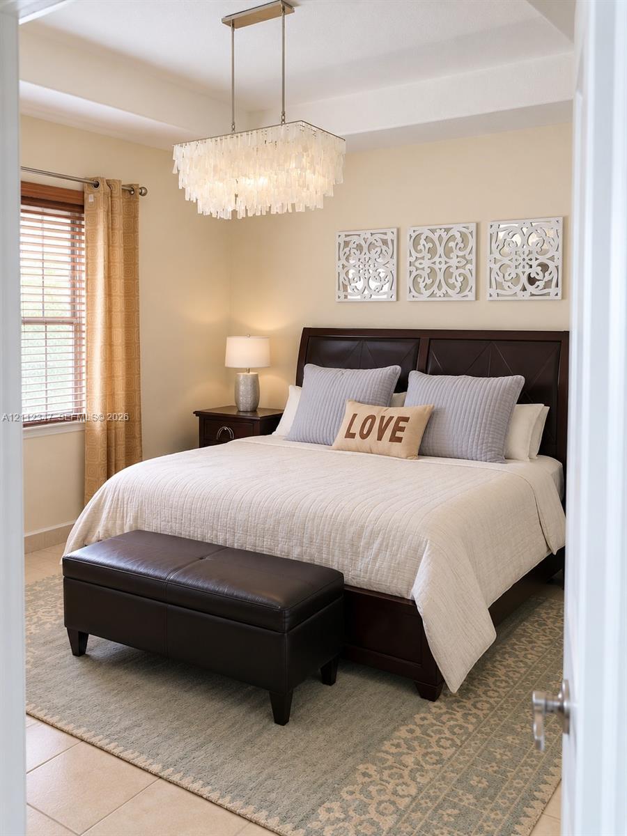 Tray ceiling, multi-tiered white pendant chandelier, and large-format tile flooring