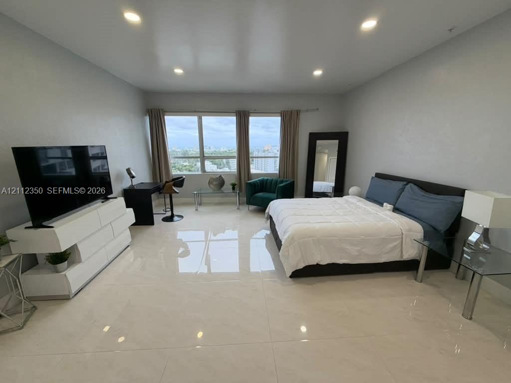 Large-format tile flooring, recessed ceiling lighting, and expansive windows featuring exterior horizon exposure Large-format tile flooring, recessed ceiling lighting, and expansive windows featuring exterior horizon exposure