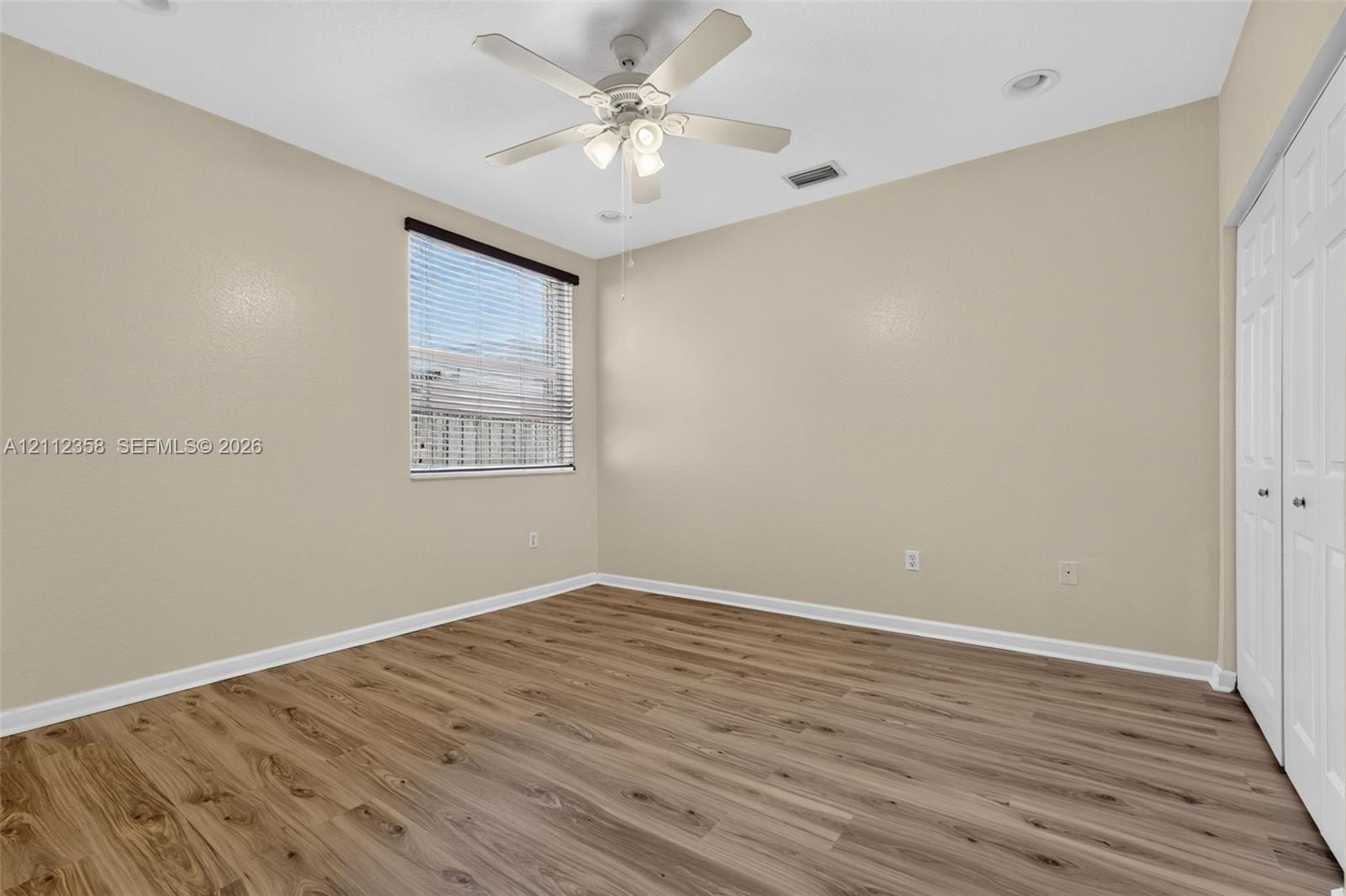 Ground floor Room featuring wood-finish flooring, a white ceiling fan with integrated lighting, recessed lighting, and white bifold closet doors