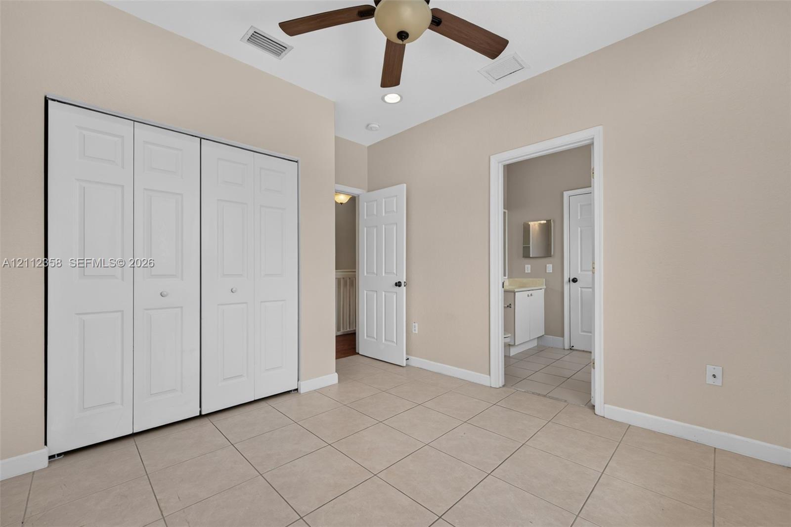 Room featuring neutral tile flooring, bi-fold closet doors, a multi-blade ceiling fan, and recessed lighting