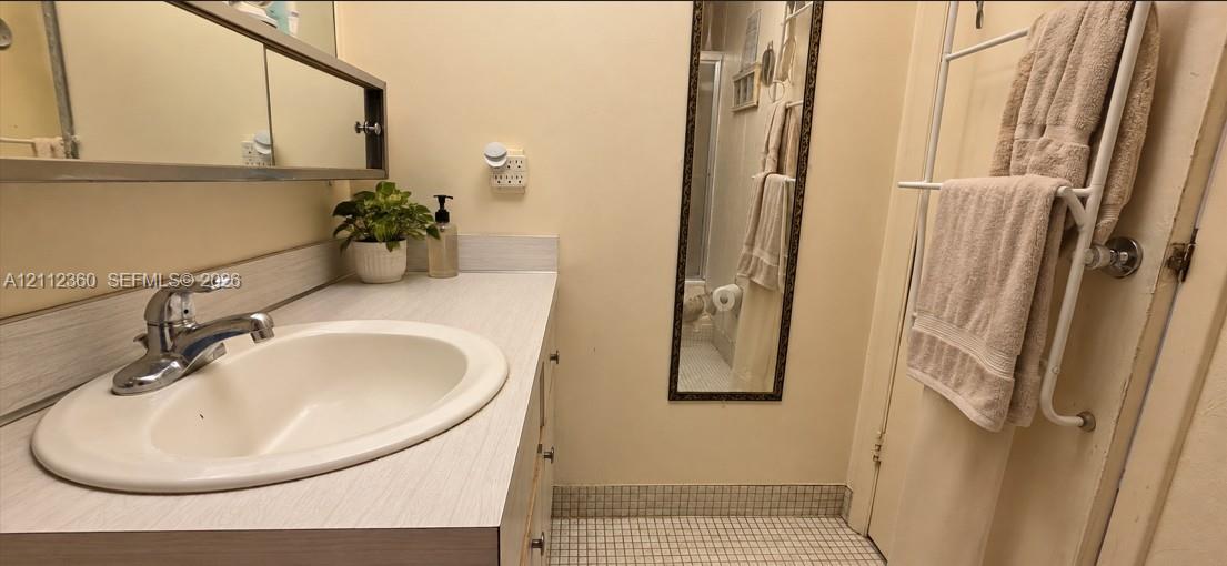 Vanity featuring a laminate countertop, integrated oval basin, chrome-finish faucet, and a wall-mounted medicine cabinet with a mirror