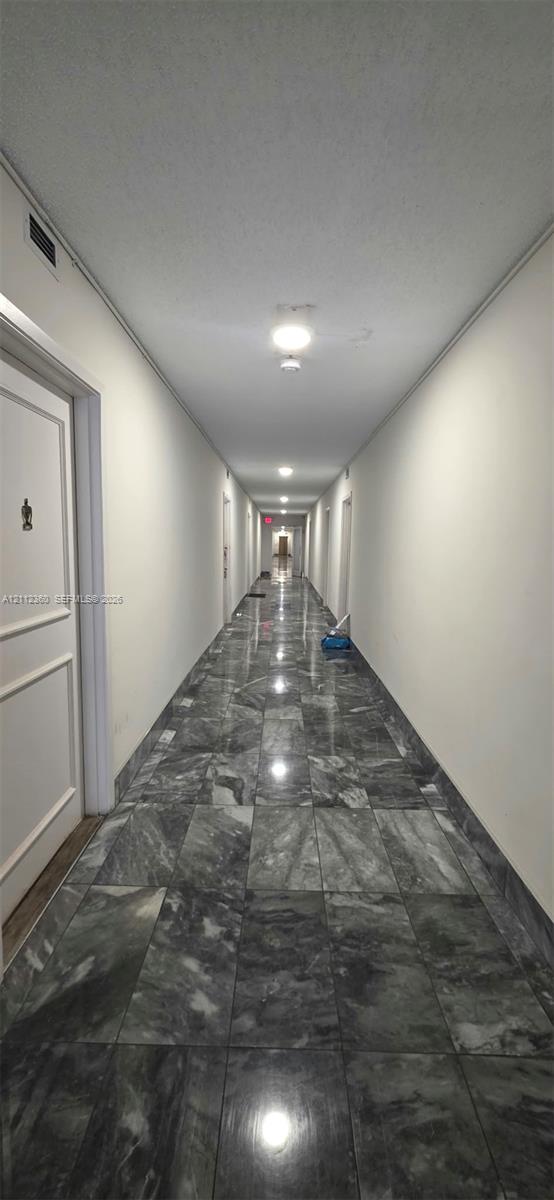 Polished stone tile flooring, neutral wall finishes, and recessed ceiling lighting