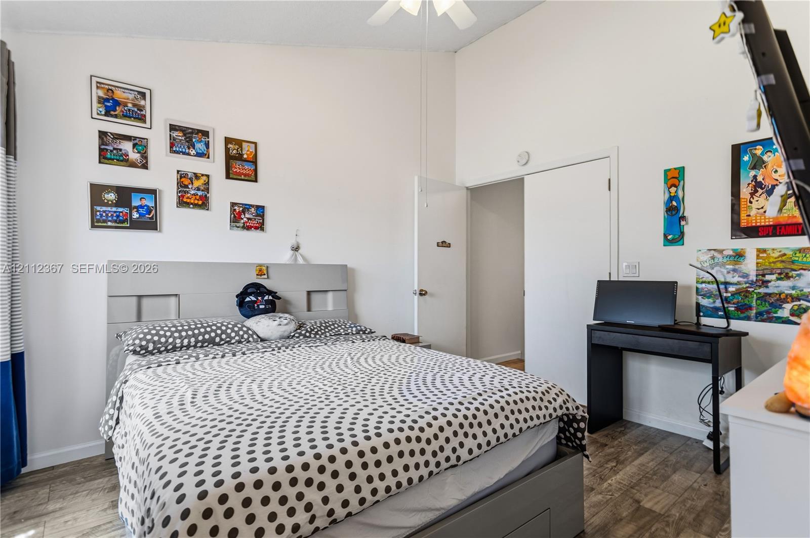 Vaulted ceiling, wood-finish flooring, and a ceiling fan with integrated lighting