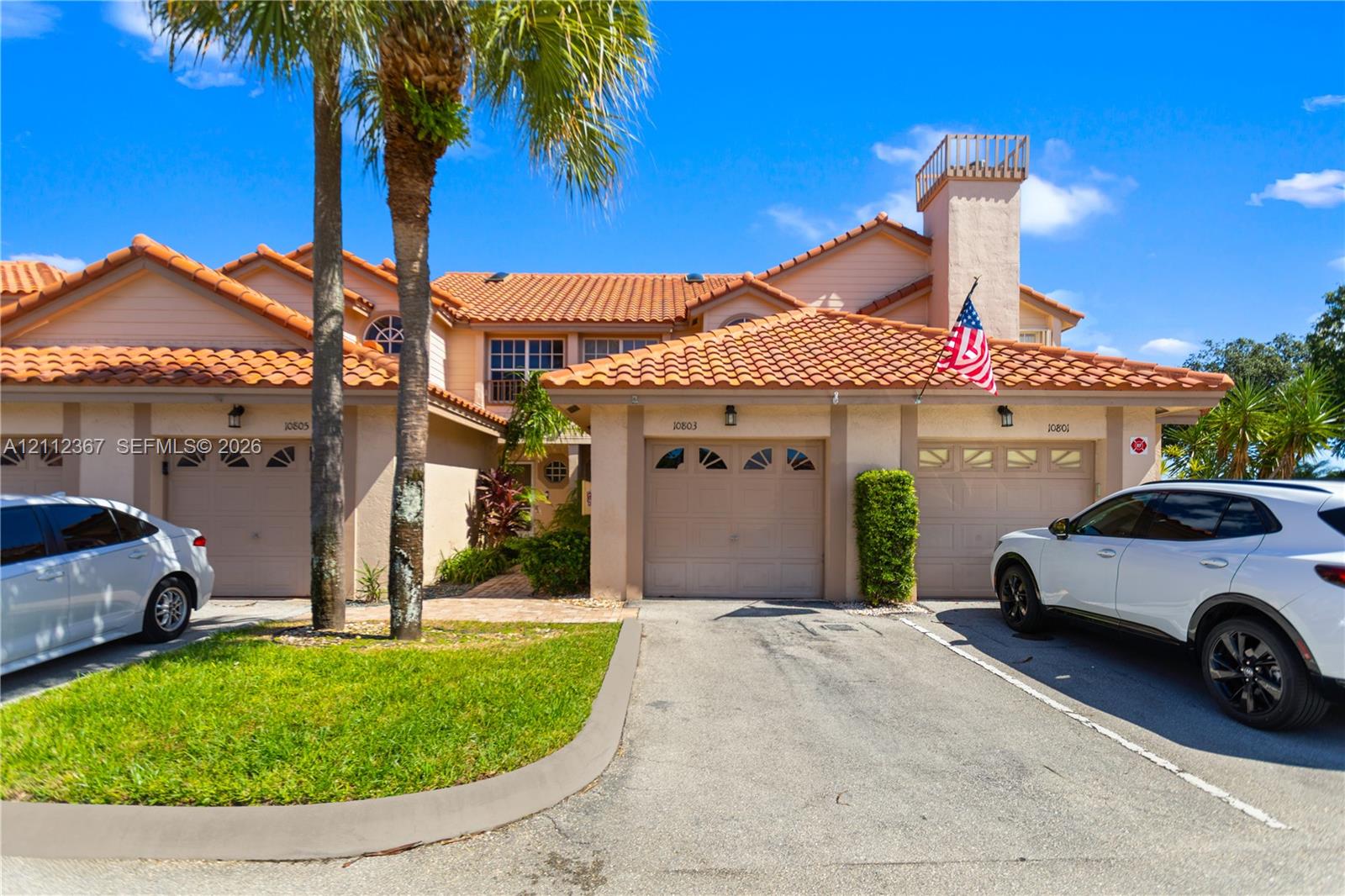 Spanish-style exterior featuring a clay tile roof, stucco facade, and multiple attached garages