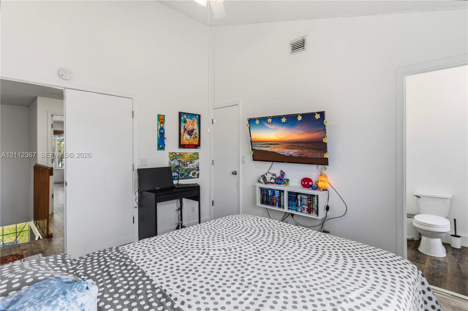 Vaulted ceiling, wood-finish flooring, and wall-mounted shelving unit