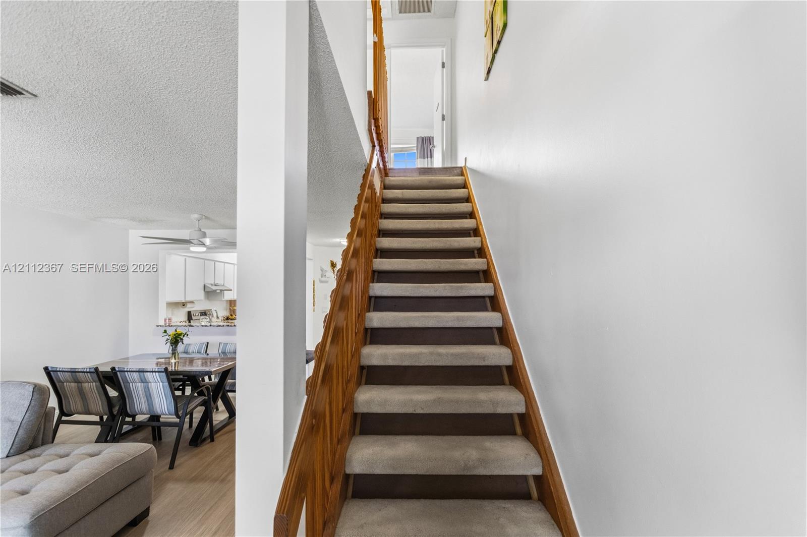 Staircase featuring wood railings and neutral carpeting