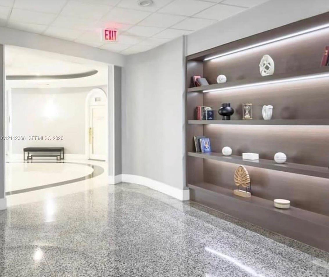 Built-in floor-to-ceiling shelving featuring integrated LED accent lighting and polished stone flooring