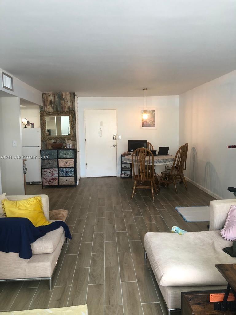 Open-concept interior featuring wood-finish tile flooring and a dedicated pendant light fixture