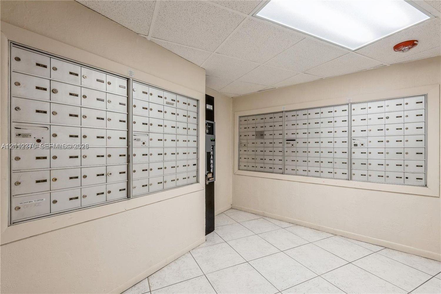 Mailroom featuring wall-mounted metal mailboxes and tiled flooring Mailroom featuring wall-mounted metal mailboxes and tiled flooring