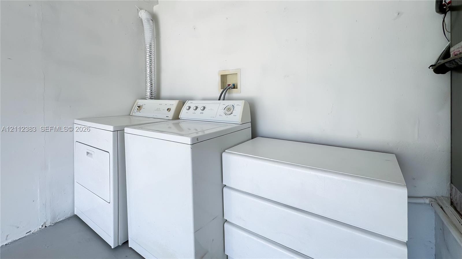 Utility space featuring white laundry appliances and a built-in white storage unit