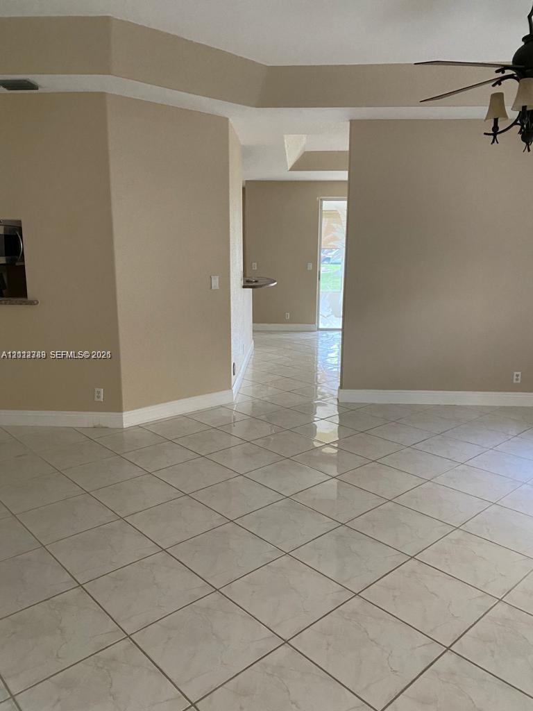 Ceramic tile flooring arranged in a diagonal pattern, recessed ceiling detailing, built-in breakfast bar, and an attached multi-arm light fixture