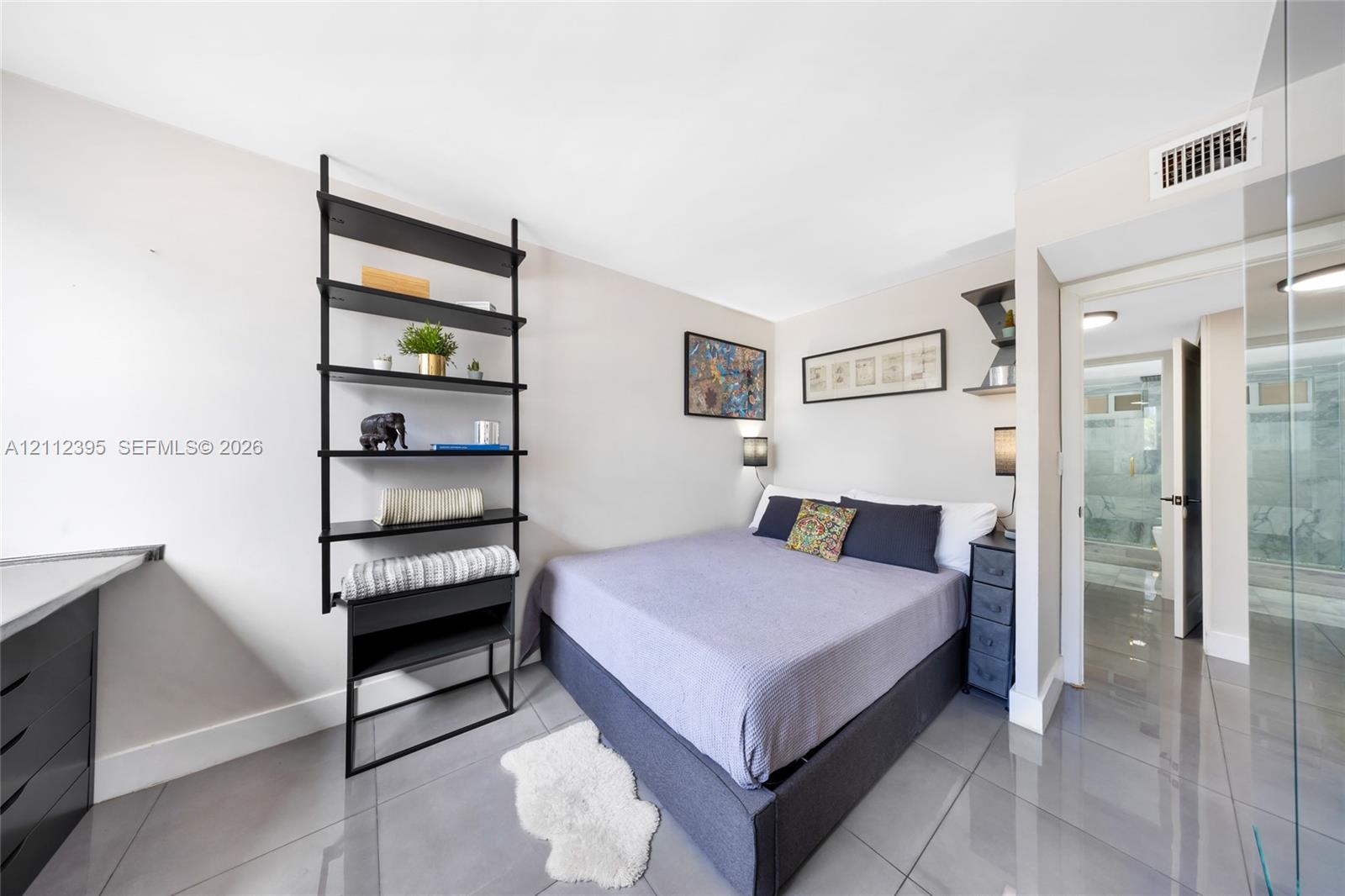 Polished tile flooring, wall-mounted black metal shelving, and sleek built-in desk cabinetry