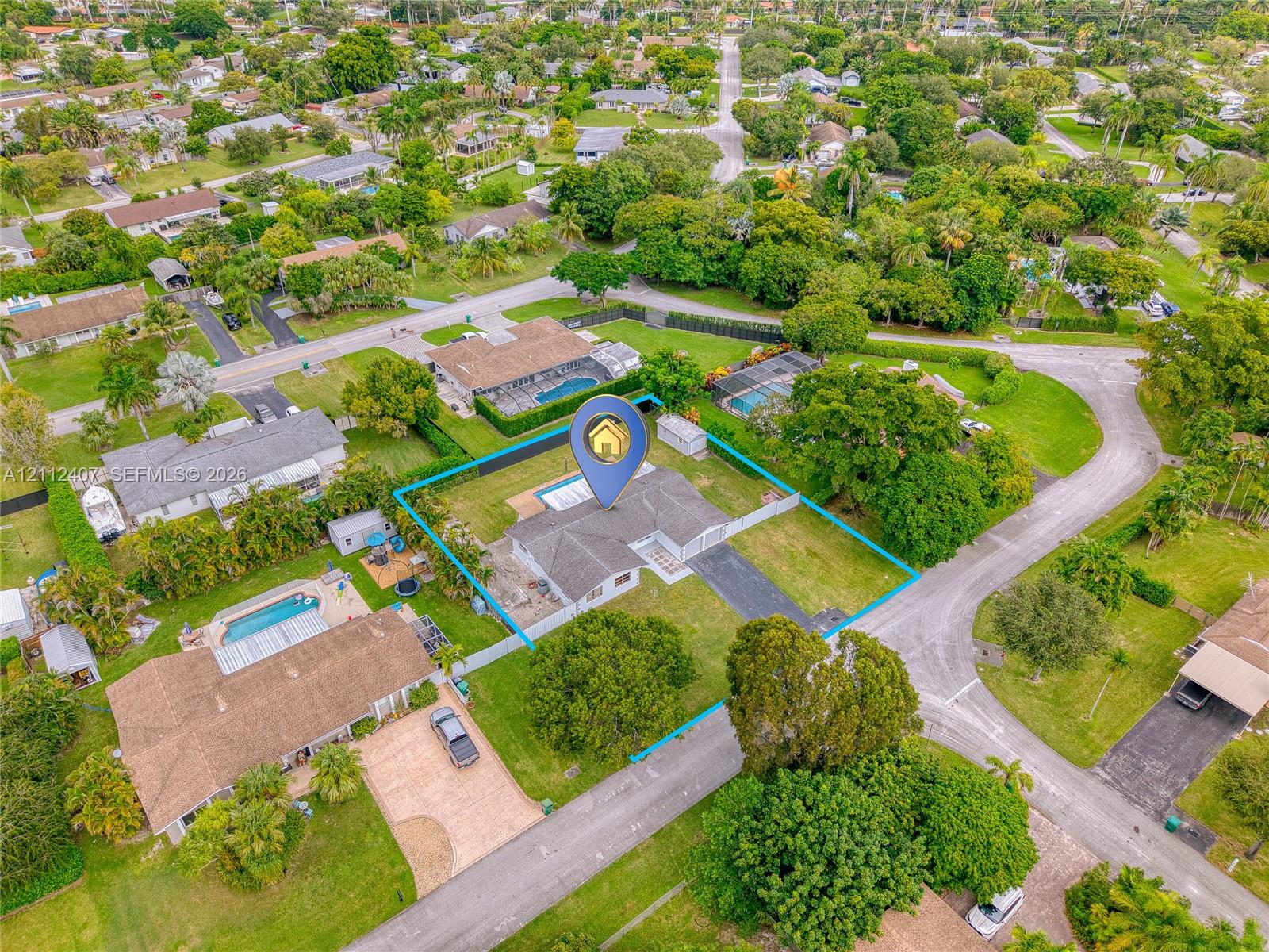 Single-story residence featuring a shingled roof, asphalt driveway, and a fenced rear perimeter, situated on a corner lot with mature landscaping