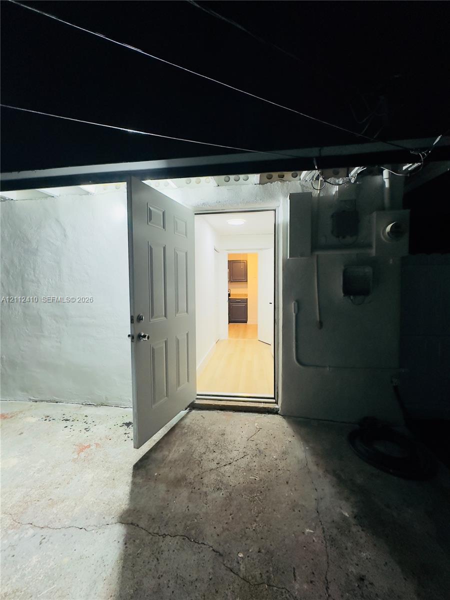Exterior entrance featuring a six-panel door, concrete flooring, and smooth-finish exterior walls