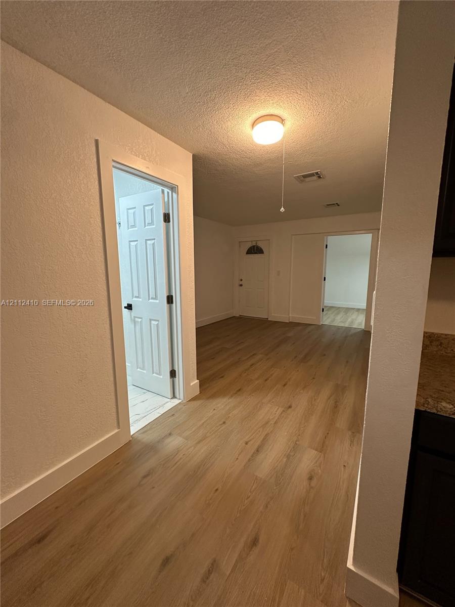 Wood-finish flooring throughout, multi-panel interior doors with matte black hardware, and crisp white trim