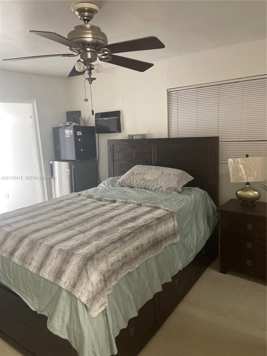 Ceiling fan with integrated lighting, horizontal window blinds, and tile flooring