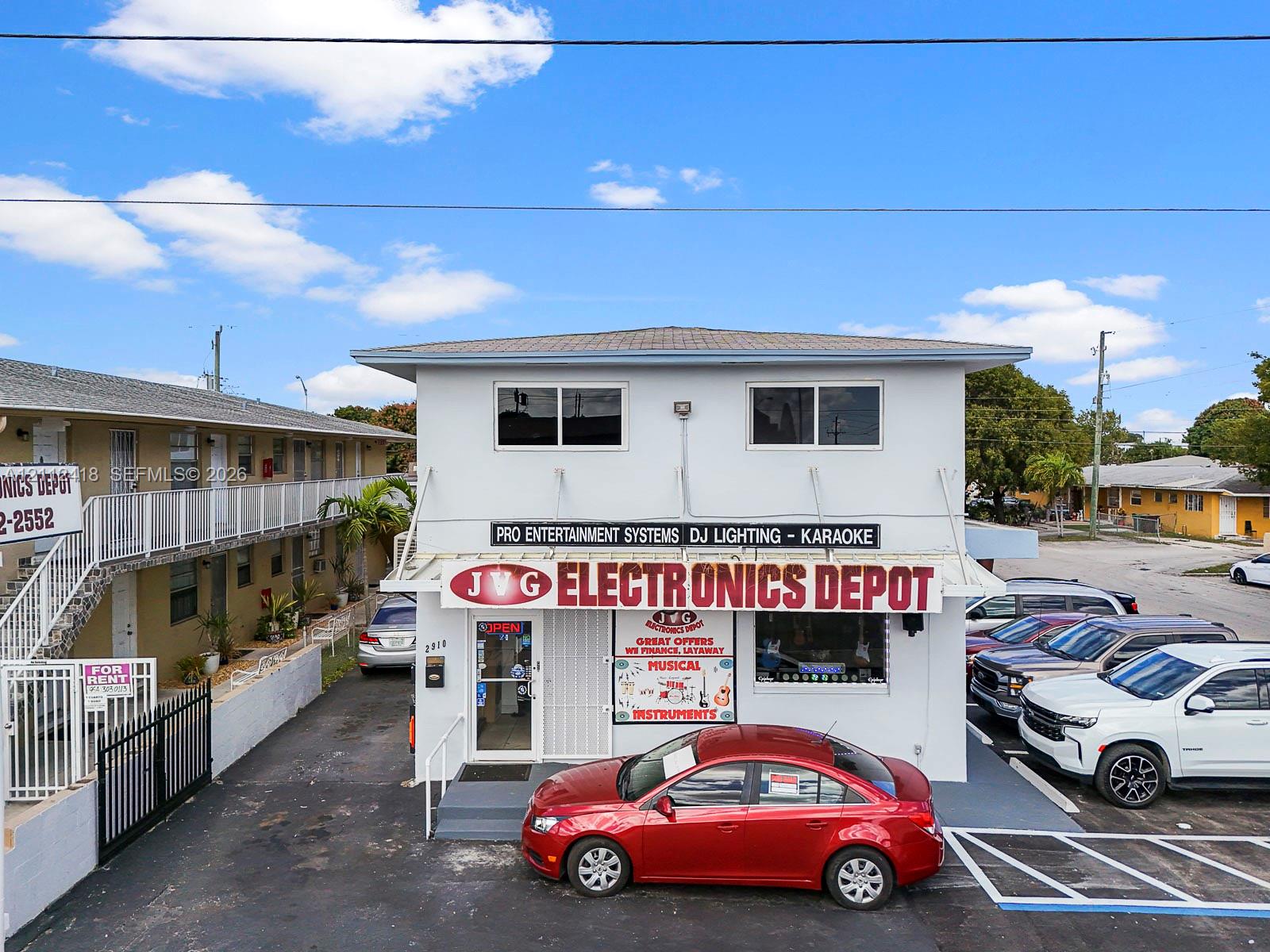 Two-story commercial building featuring a flat roof, concrete block construction, ground-level glass entry, and dedicated asphalt parking area Two-story commercial building featuring a flat roof, concrete block construction, ground-level glass entry, and dedicated asphalt parking area
