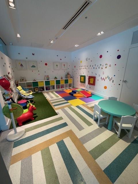 Multi-purpose room featuring recessed ceiling lighting, integrated cubby storage, and patterned vinyl flooring