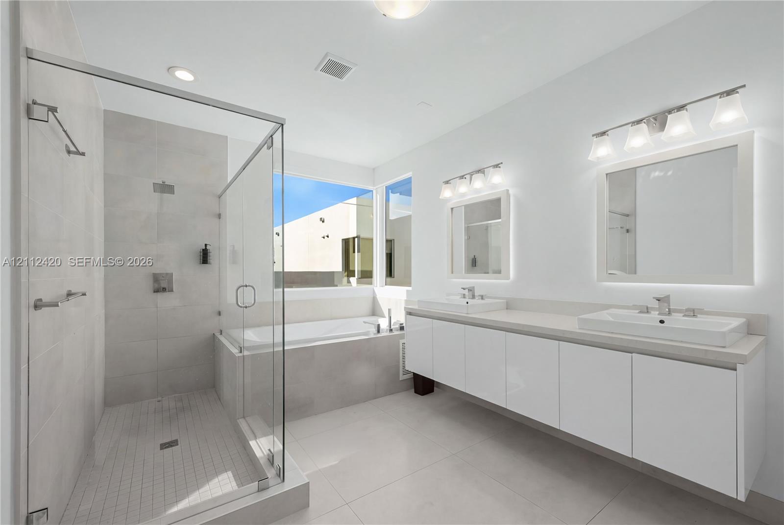 Double vanity featuring high-gloss cabinetry, rectangular vessel sinks, quartz countertops, and dual wall-mounted light fixtures